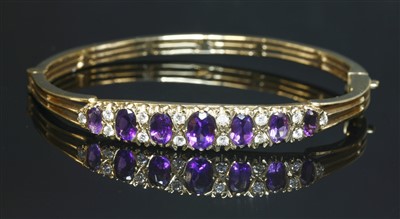 Lot 288 - A 9ct gold amethyst and diamond hinged bangle