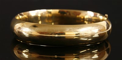 Lot 312 - A hollow 'D' section hinged gold bangle