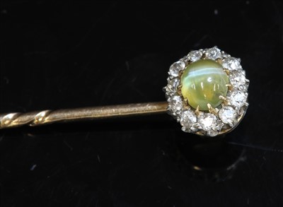 Lot 137 - A cased Edwardian chrysoberyl cat's eye and diamond cluster stick pin/dress stud