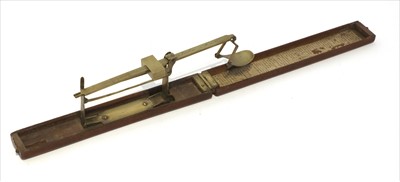 Lot 1052 - A walnut cased folding brass coin scale