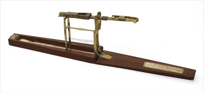 Lot 1075 - A walnut cased brass folding coin scale