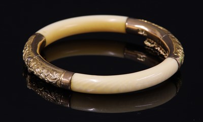 Lot 6 - An early 20th century Chinese carved ivory and gold mounted hinged bangle