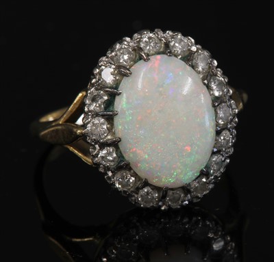Lot 221 - An 18ct gold opal and diamond oval cluster ring