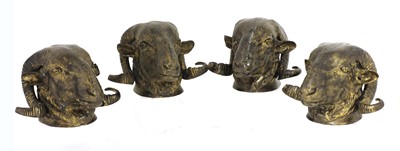 Lot 260 - A set of four gilded metal ram's head curtain pole finials
