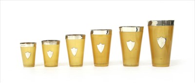 Lot 179 - A set of six graduated horn beakers with silver mounts