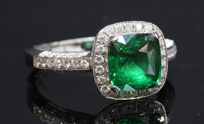 Lot 236 - An 18ct white gold tsavorite garnet and diamond halo cluster ring