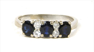 Lot 60 - A white gold seven stone sapphire and diamond ring