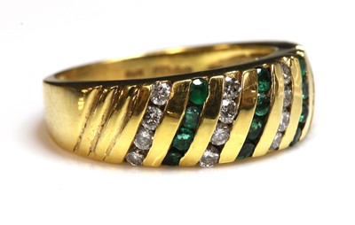 Lot 239 - An 18ct gold emerald and diamond diagonal band ring