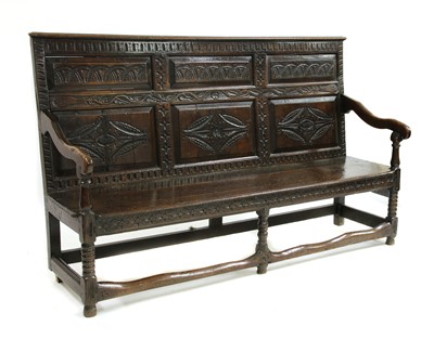 Lot 125 - A carved oak settle
