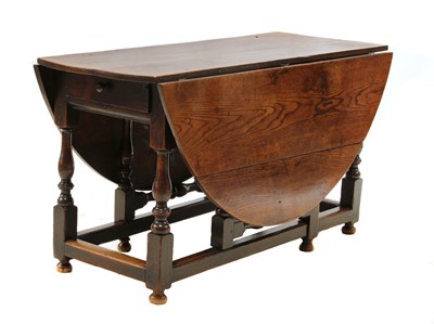 Lot 115 - An oak drop-leaf gate leg dining table
