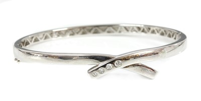 Lot 407 - An 18ct white gold diamond set crossover bangle