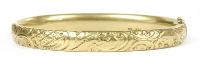 Lot 101 - A gold hollow hinged oval bangle