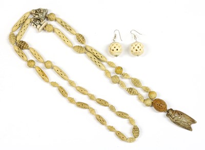 Lot 340 - A pair of spherical carved pierced bone drop earrings