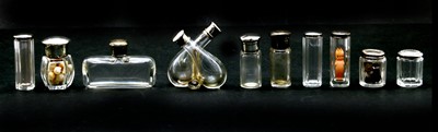 Lot 43 - A collection of silver lidded glass scent and drawing table jars