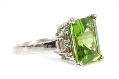 Lot 327 - A white gold single stone peridot ring with diamond set shoulders