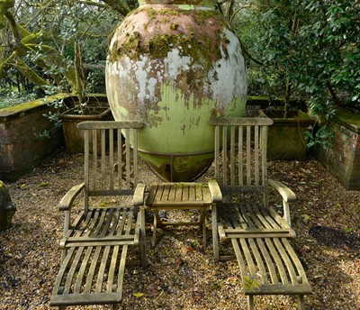 Lot 457 - A pair of teak and brass reclining steamer lounge chairs