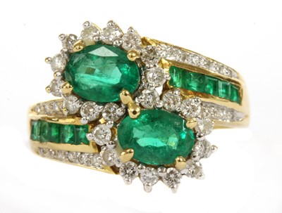 Lot 161 - An 18ct gold emerald and diamond cluster crossover ring