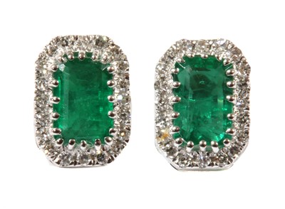 Lot 149 - A pair of white gold emerald and diamond cluster earrings