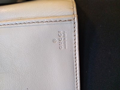 Lot 101 - A Gucci beige monogrammed canvas and cream leather heart bi-fold wallet
