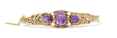 Lot 133 - A 9ct gold amethyst and split pearl bangle