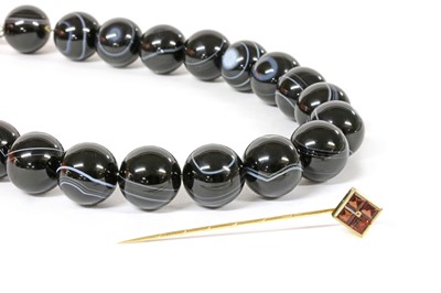 Lot 426 - A gold garnet stick pin
