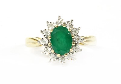 Lot 100 - A gold emerald and diamond cluster ring