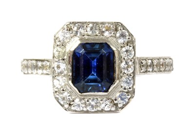 Lot 128 - An 18ct white gold sapphire and white sapphire halo cluster ring
