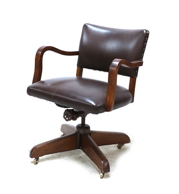 Lot 541 - An oak and studded leather revolving office chair