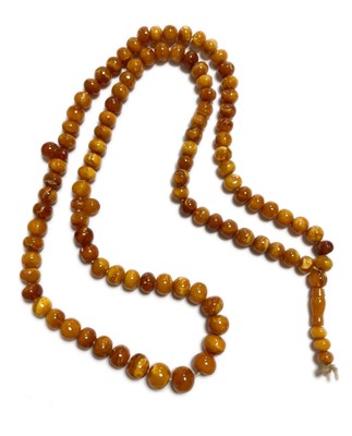 Lot 27 - A single row slightly graduated butterscotch amber prayer bead necklace