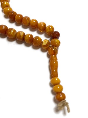 Lot 27 - A single row slightly graduated butterscotch amber prayer bead necklace