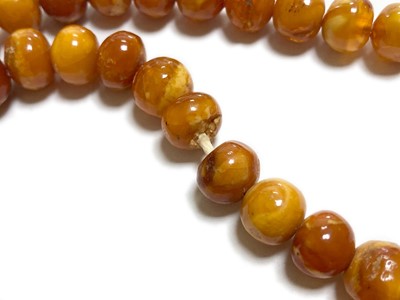 Lot 27 - A single row slightly graduated butterscotch amber prayer bead necklace