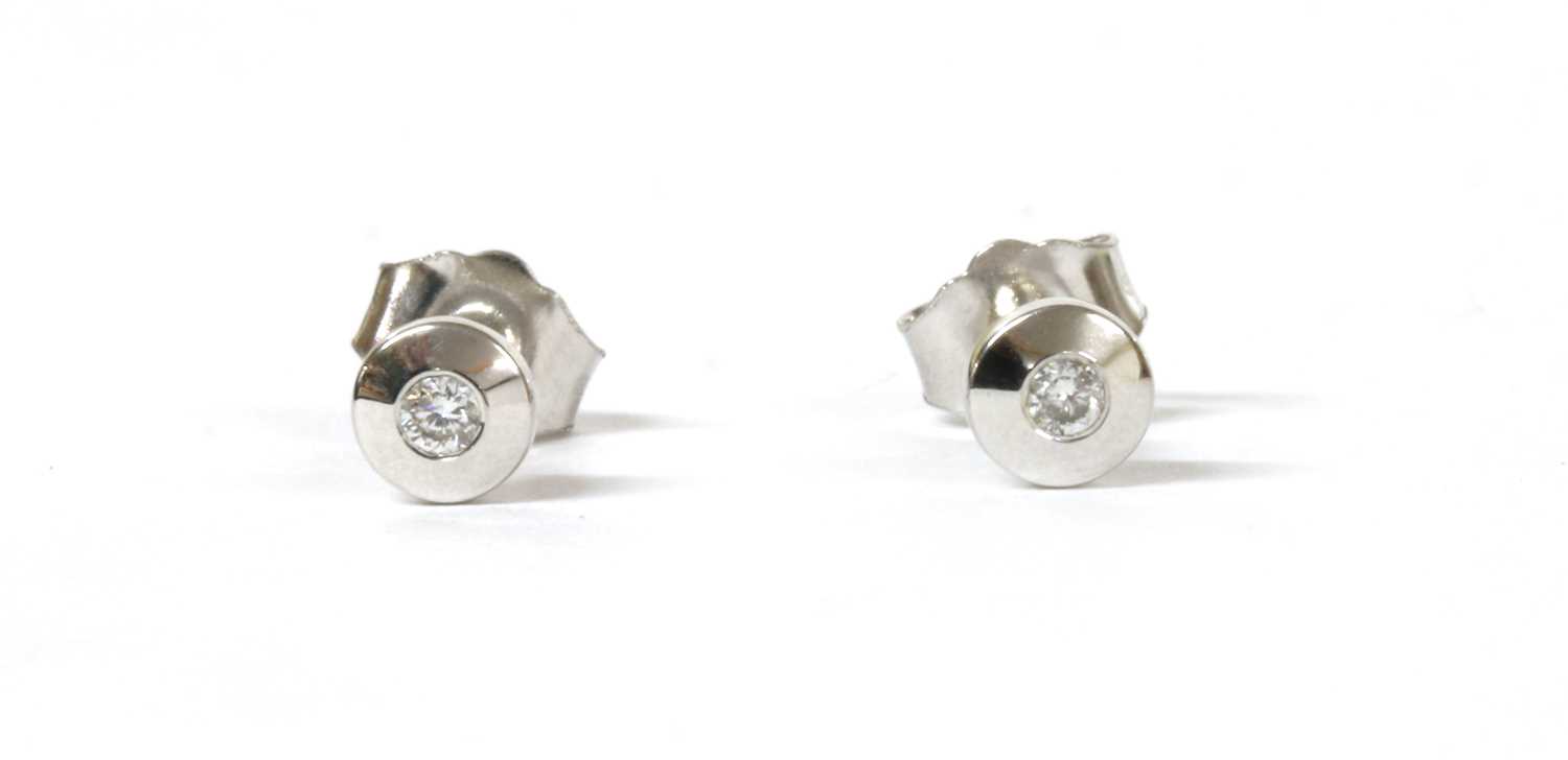 Lot 110 - A pair of white gold single stone diamond stud earrings