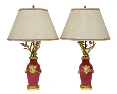 Lot 59 - A pair of ormolu-mounted pink ground vase lamps