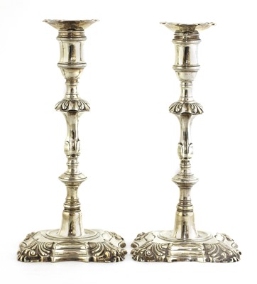 Lot 504 - A pair of cast silver table candlesticks