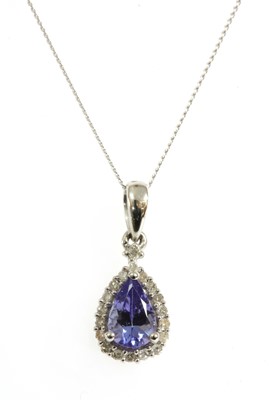Lot 130 - A white gold tanzanite and diamond halo cluster pendant