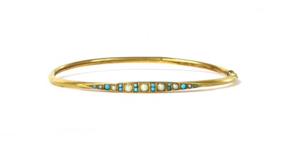 Lot 1036 - An Edwardian gold split pearl and turquoise oval bangle