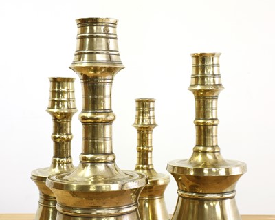 Lot 391 - A graduated set of four bell-shaped brass candlesticks