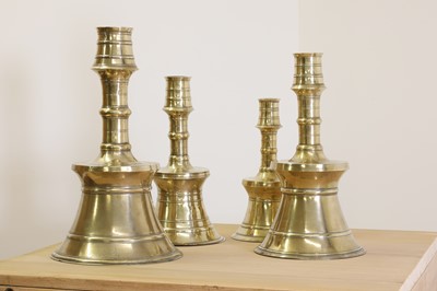 Lot 391 - A graduated set of four bell-shaped brass candlesticks