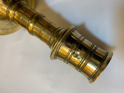 Lot 391 - A graduated set of four bell-shaped brass candlesticks