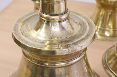 Lot 391 - A graduated set of four bell-shaped brass candlesticks