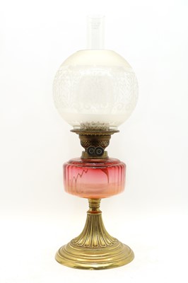 Lot 256 - A Victorian brass and cranberry glass oil lamp
