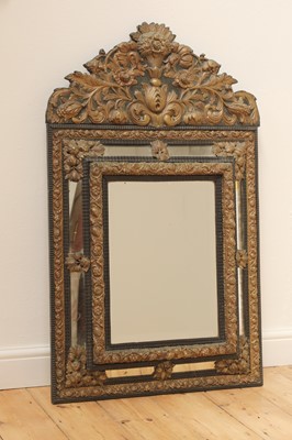 Lot 215 - An ebonised and embossed brass wall mirror