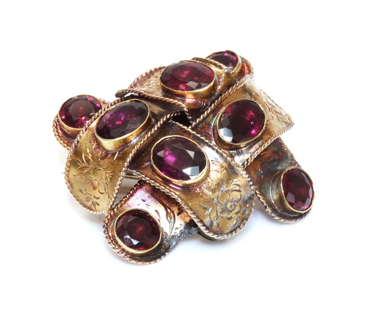 Lot 57 - A Victorian garnet set ribbon style knot brooch