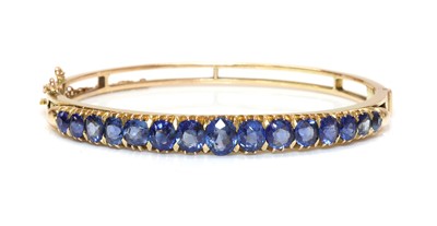 Lot 97 - A late Victorian sapphire set hinged bangle, c.1900