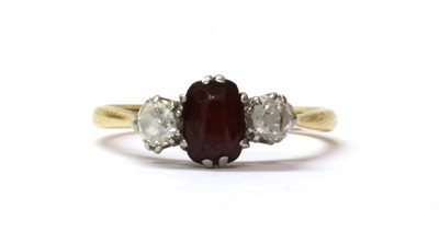 Lot 136 - A gold garnet and diamond three stone ring