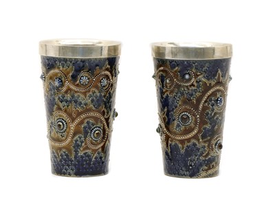 Lot 134 - A pair of Doulton Lambeth stoneware and silver mounted beakers
