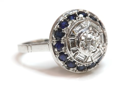 Lot 261 - A white gold diamond and sapphire circular stepped cluster ring