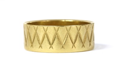 Lot 120 - An 18ct gold patterned flat section wedding ring