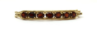 Lot 242 - A gold garnet bangle