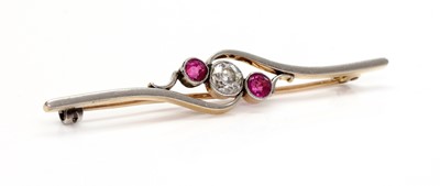 Lot 192 - A three stone diamond and ruby crossover bar brooch